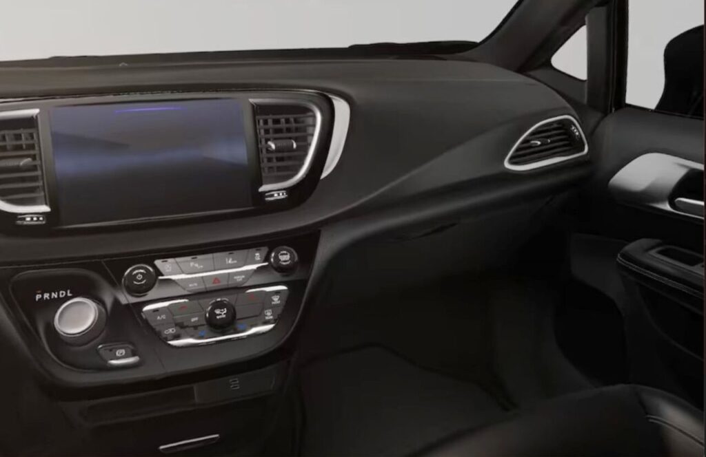 Habitacle arrière d’une Chrysler Pacifica avec sièges noirs et troisième rangée spacieuse, mettant en valeur le confort et la capacité familiale du véhicule.
