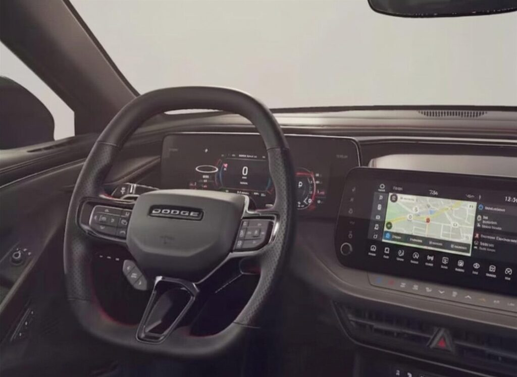 Habitacle moderne d’une Dodge Charger avec volant multifonction Dodge, tableau de bord numérique, écran tactile central avec navigation intégrée et intérieur au design technologique et sportif.